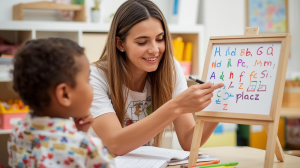 Guru privat menggunakan papan tulis kecil atau media visual saat mengajar anak
